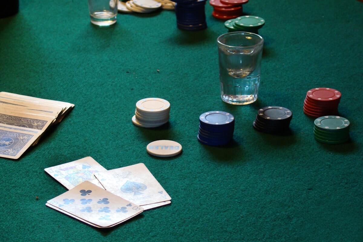 A clay poker chip set on a table next to a phone showing a digital chip stack in PartyPot